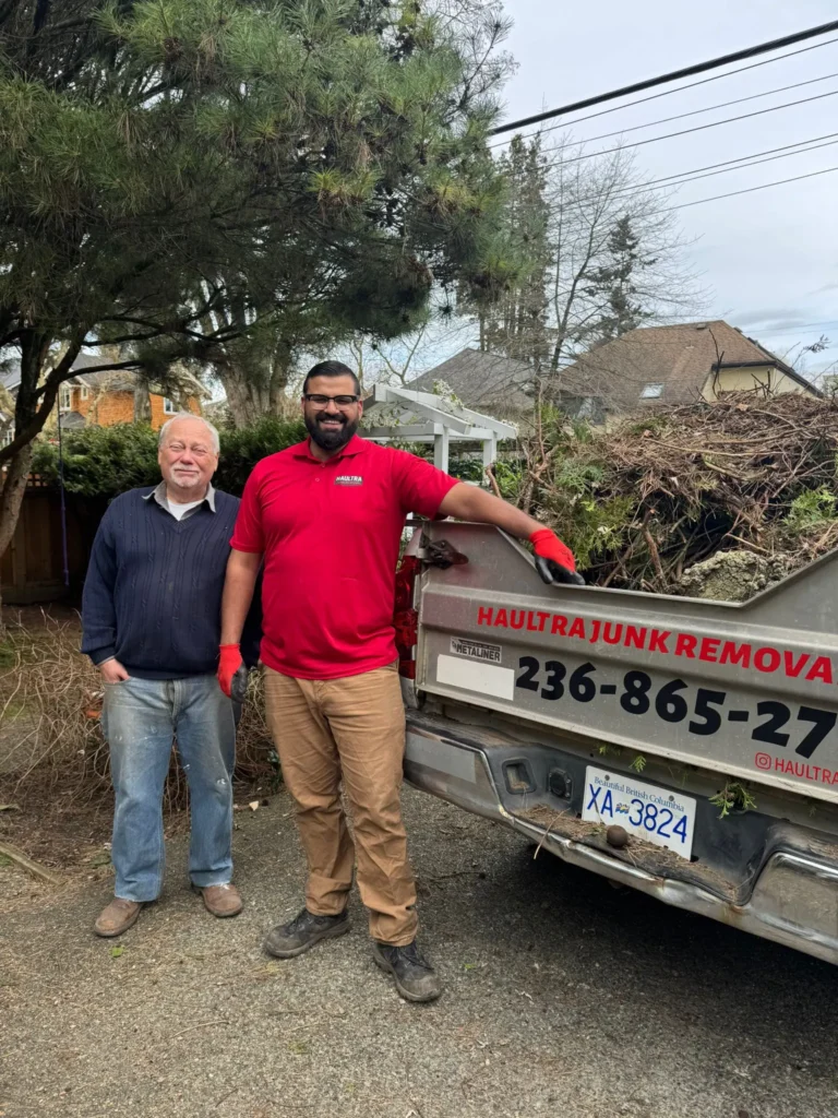 Your local residential junk removal team with a Haultra professional and customer beside a loaded junk removal truck.