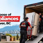 Haultra Junk Removal team loading an old refrigerator and household appliances into a junk removal truck in Vancouver, BC.